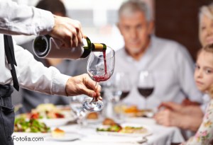 Kellner gießt Wein in ein Glas